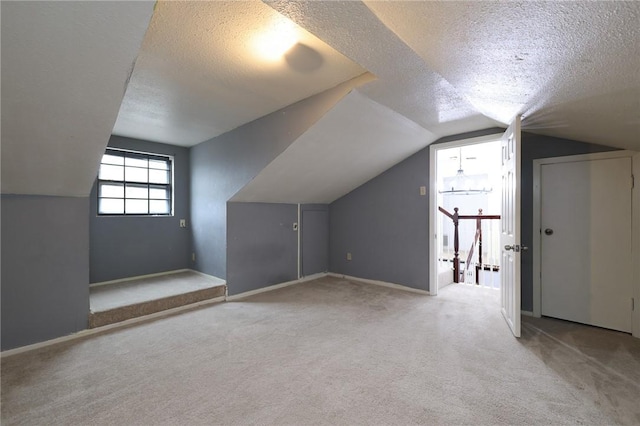 bonus room featuring a textured ceiling, light colored carpet, and vaulted ceiling