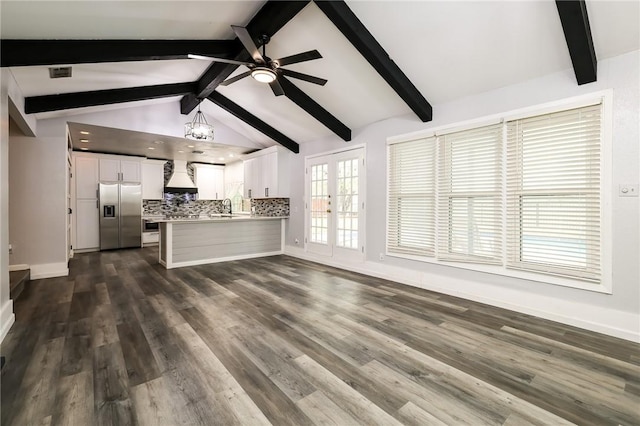 unfurnished living room featuring vaulted ceiling with beams, french doors, dark hardwood / wood-style floors, sink, and ceiling fan with notable chandelier