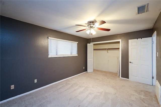 unfurnished bedroom with ceiling fan, a closet, and light carpet