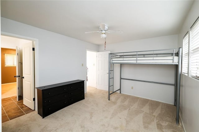 bedroom featuring ceiling fan, multiple windows, and carpet flooring