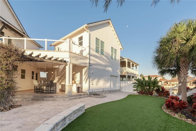 back of property with a lawn, a patio, and fence