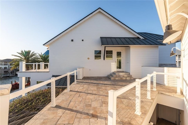 rear view of house featuring metal roof and a standing seam roof