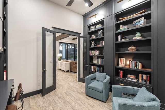 sitting room with built in shelves, a ceiling fan, baseboards, light wood-style floors, and french doors