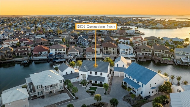 aerial view at dusk with a residential view and a water view