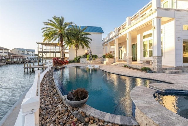 outdoor pool with a boat dock, a patio, and a water view