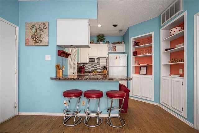 14721 Whitecap Blvd Unit 183, Corpus Christi, TX 78418 - kitchen with white appliances, open shelves, dark wood finished floors, white cabinetry, and a peninsula