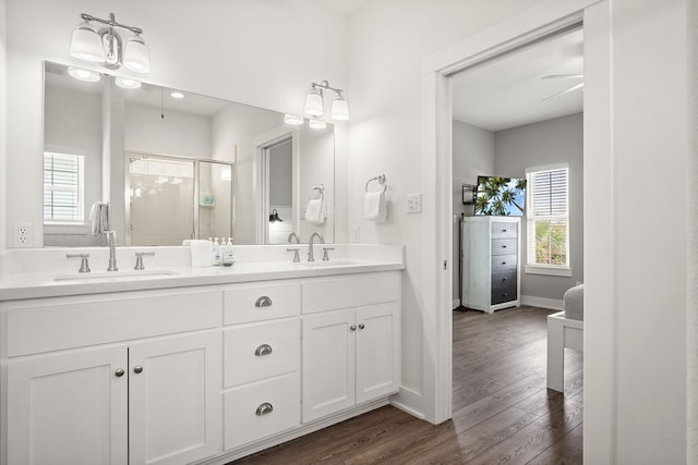 bathroom featuring a shower with door, vanity, hardwood / wood-style flooring, and ceiling fan