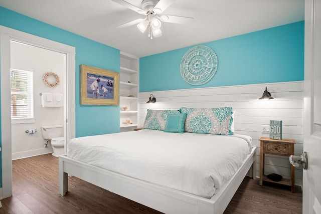 bedroom with dark wood-type flooring, ceiling fan, and connected bathroom