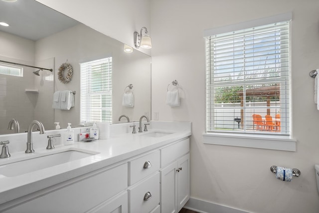 bathroom with a wealth of natural light, vanity, and a shower with door