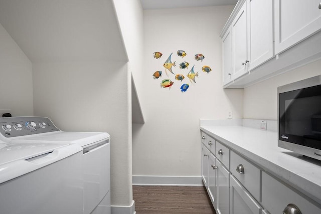 clothes washing area featuring washer and dryer, baseboards, dark wood-type flooring, and cabinet space