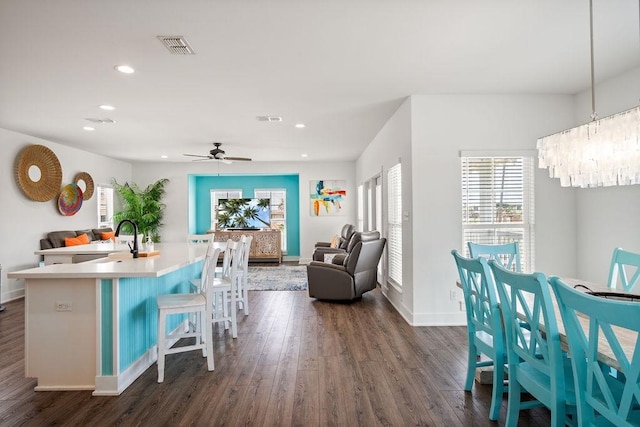 kitchen with a sink, recessed lighting, dark wood-style flooring, open floor plan, and a kitchen island with sink
