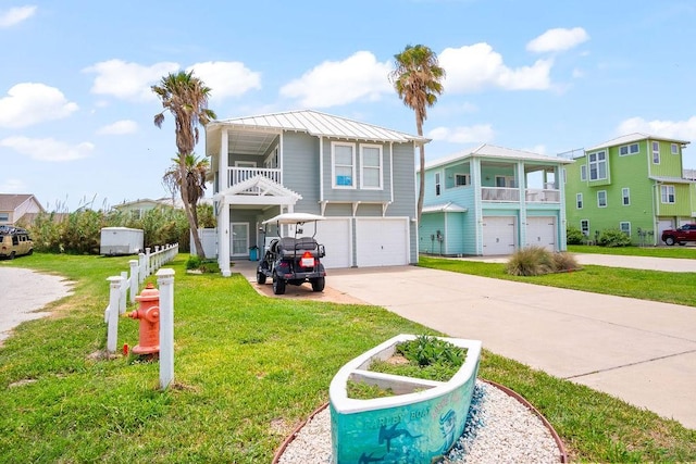 coastal home featuring a garage, concrete driveway, a front yard, and a residential view