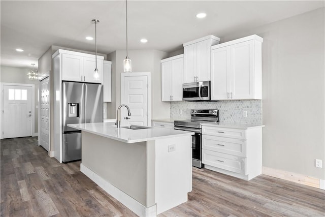 15501 Cruiser St Unit A, Corpus Christi, TX 78418 - kitchen featuring stainless steel appliances, decorative backsplash, light countertops, an island with sink, and white cabinetry