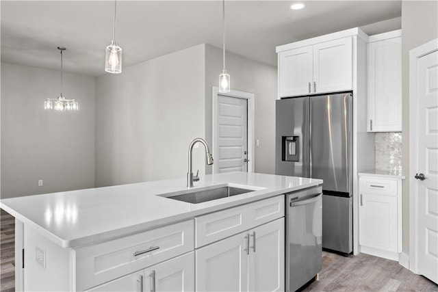 15501 Cruiser St Unit A, Corpus Christi, TX 78418 - kitchen featuring appliances with stainless steel finishes, light wood-type flooring, a center island with sink, white cabinetry, and light countertops