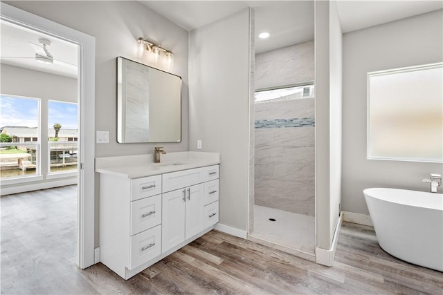 15501 Cruiser St Unit A, Corpus Christi, TX 78418 - bathroom with walk in shower, vanity, wood finished floors, a soaking tub, and recessed lighting