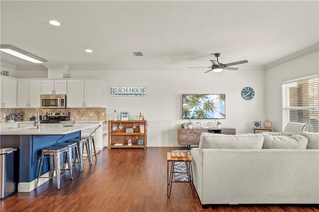 living room with crown molding, ceiling fan, dark hardwood / wood-style flooring, and sink