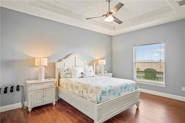 bedroom with dark hardwood / wood-style floors, a raised ceiling, and ceiling fan