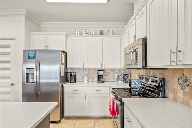 kitchen featuring appliances with stainless steel finishes, white cabinets, backsplash, light tile patterned floors, and crown molding