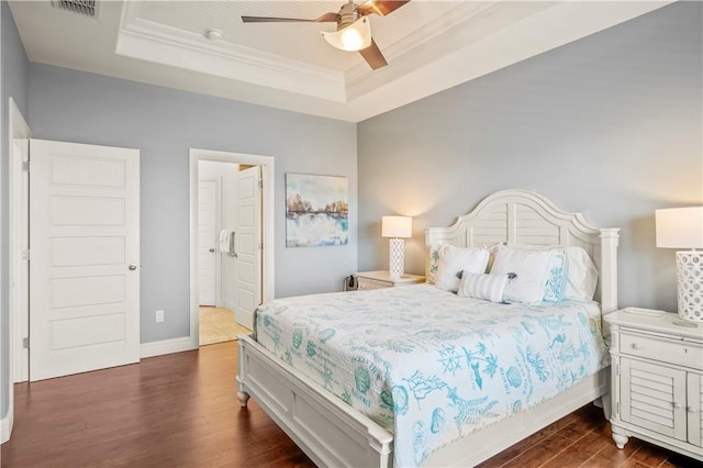 bedroom with crown molding, ceiling fan, a tray ceiling, and dark hardwood / wood-style flooring