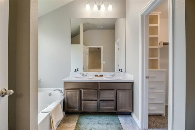 6753 Mikayla St, Corpus Christi, TX 78413 - bathroom with double vanity, a garden tub, vaulted ceiling, and a spacious closet
