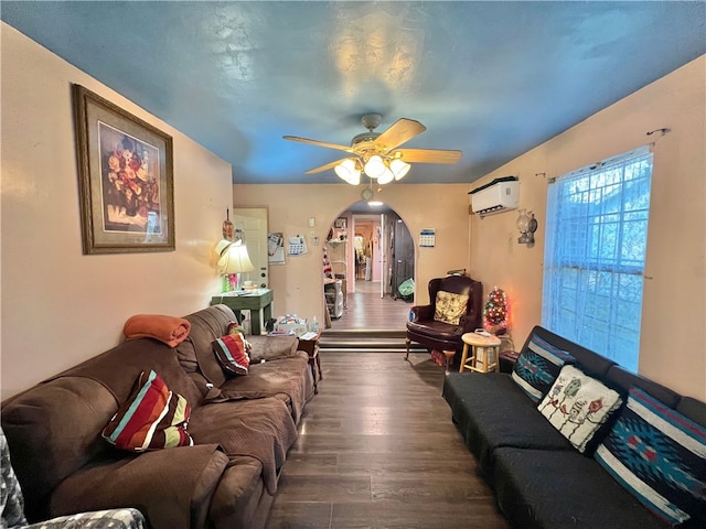 living room featuring dark wood-type flooring, ceiling fan, and a wall unit AC