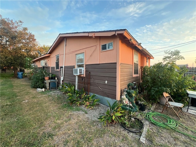 property exterior at dusk featuring cooling unit and a yard