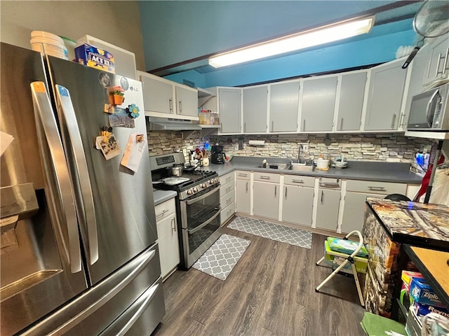 kitchen featuring dark wood-type flooring, sink, appliances with stainless steel finishes, decorative backsplash, and white cabinets