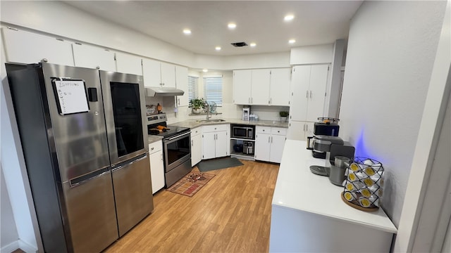 kitchen with white cabinetry, sink, light hardwood / wood-style floors, and appliances with stainless steel finishes