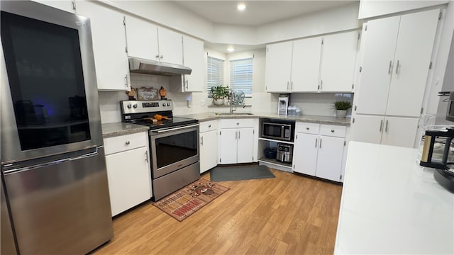 kitchen with sink, stainless steel appliances, white cabinetry, and light hardwood / wood-style flooring