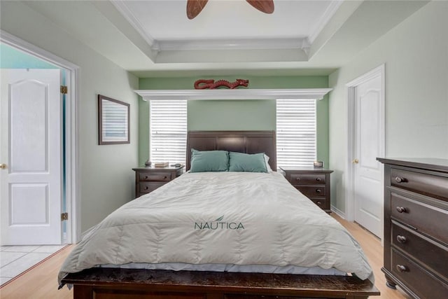 7313 Prairie Dr, Corpus Christi, TX 78413 - bedroom with crown molding, light wood-type flooring, a tray ceiling, and a ceiling fan