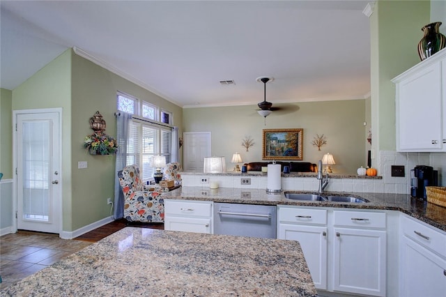 kitchen with crown molding, stone counters, sink, white cabinets, and kitchen peninsula