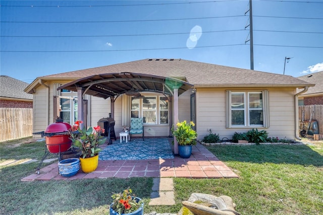 rear view of property featuring a lawn, a patio, and a gazebo