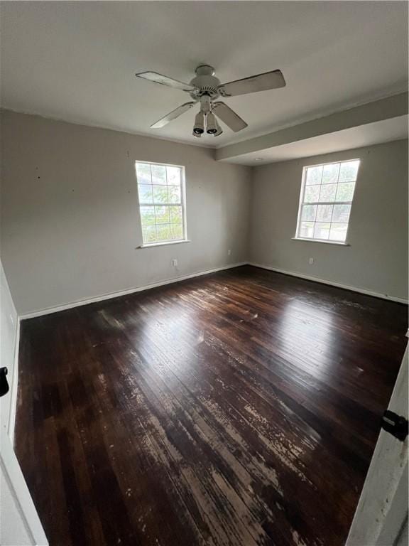 unfurnished room featuring dark wood-type flooring, plenty of natural light, and ceiling fan