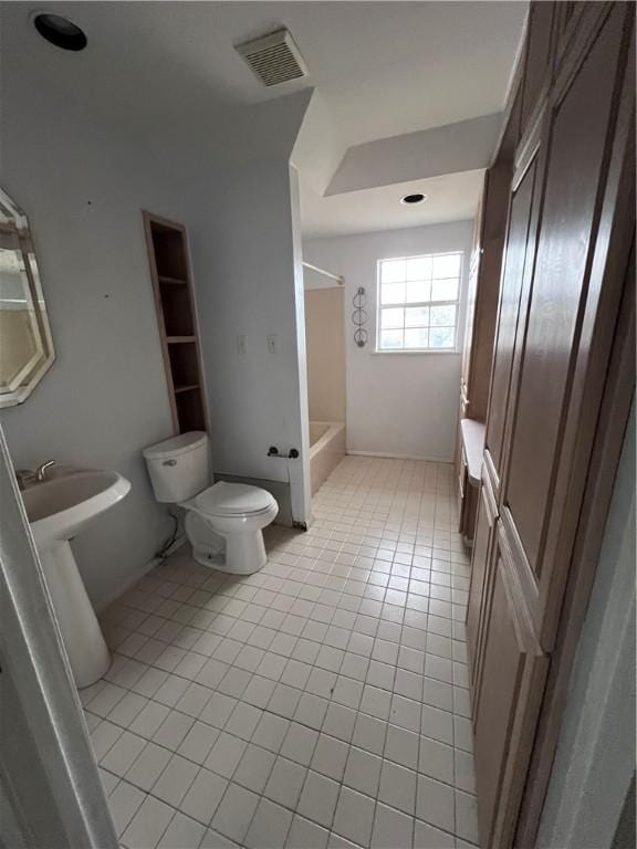 full bathroom with sink, tile patterned floors, toilet, and washtub / shower combination