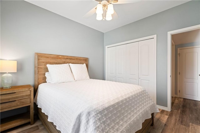 bedroom with a ceiling fan, wood finished floors, a closet, and baseboards