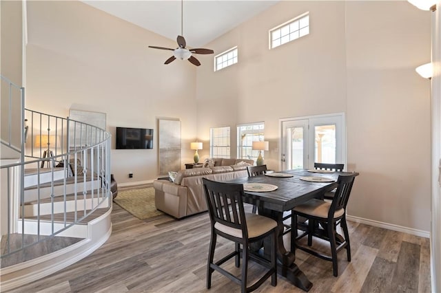 dining area with baseboards, a ceiling fan, and wood finished floors