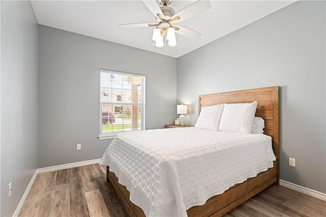 bedroom featuring a ceiling fan, baseboards, and wood finished floors