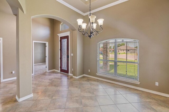 6901 Ridgeline Ct, Corpus Christi, TX 78413 - entryway with ornamental molding, light tile patterned flooring, arched walkways, a high ceiling, and a chandelier