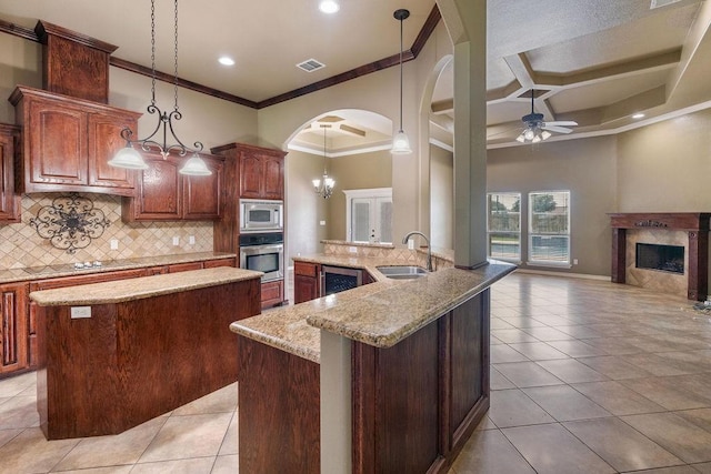 6901 Ridgeline Ct, Corpus Christi, TX 78413 - kitchen featuring a sink, appliances with stainless steel finishes, a kitchen island, a fireplace, and crown molding