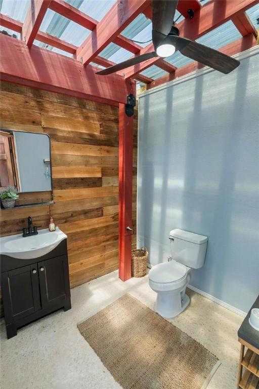 6901 Ridgeline Ct, Corpus Christi, TX 78413 - half bath featuring toilet, a ceiling fan, vanity, and wooden walls