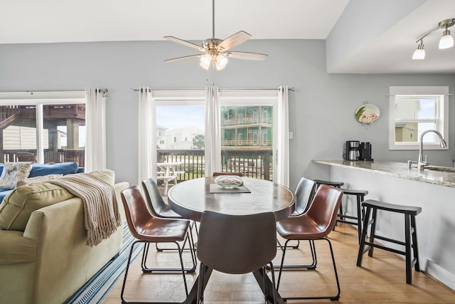 dining space with ceiling fan, sink, and light wood-type flooring