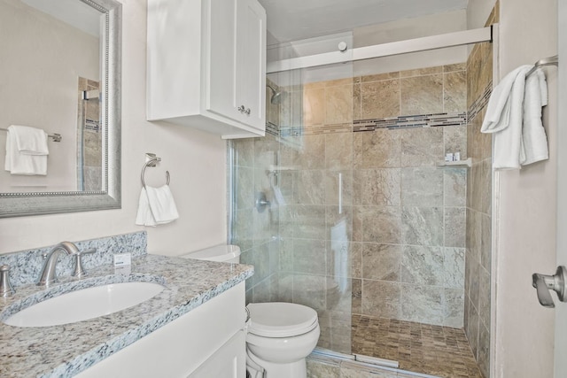 bathroom featuring an enclosed shower, vanity, and toilet