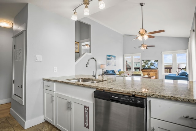 kitchen featuring dishwasher, light stone counters, sink, and vaulted ceiling