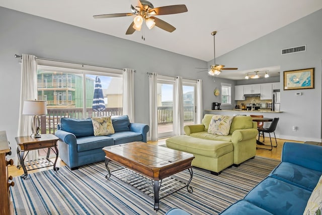 living room featuring light hardwood / wood-style floors, ceiling fan, and lofted ceiling