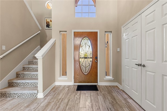 foyer featuring light hardwood / wood-style flooring and a towering ceiling