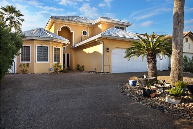 13953 Dasmarinas Dr, Corpus Christi, TX 78418 - mediterranean / spanish house with stucco siding, a garage, driveway, and a tile roof