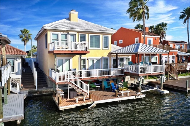 13953 Dasmarinas Dr, Corpus Christi, TX 78418 - back of house with a chimney, stairway, a water view, and stucco siding