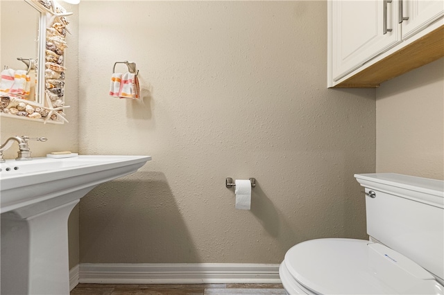 bathroom featuring hardwood / wood-style floors, toilet, and sink