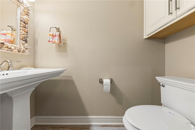 13953 Dasmarinas Dr, Corpus Christi, TX 78418 - half bath featuring toilet, baseboards, a sink, and wood finished floors