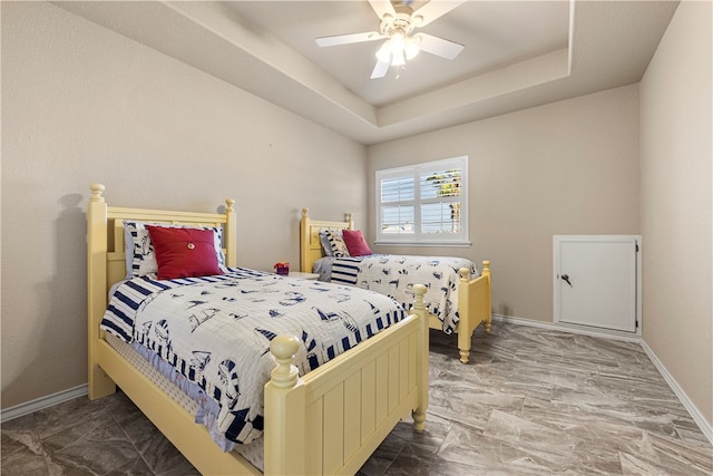 bedroom with a raised ceiling and ceiling fan